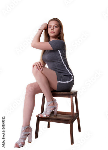 Isolated on white background girl on a stool in a dress © Ilya L