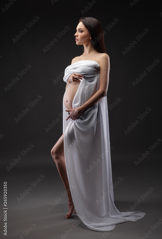Beauty and sexy of young pregnant woman with white material - grey background Beauty and sexy of young pregnant woman with white material - grey background