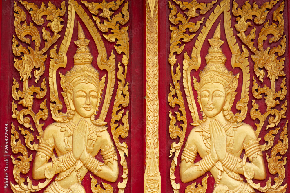 Thai buddhism angle in gold colour on red colour wood windows decorations of Thai Buddhism Temple. Songkhla city Thailand.