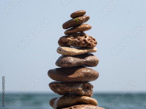 sea ​​stones to each other in the form of a tower against the background of the sea and sky