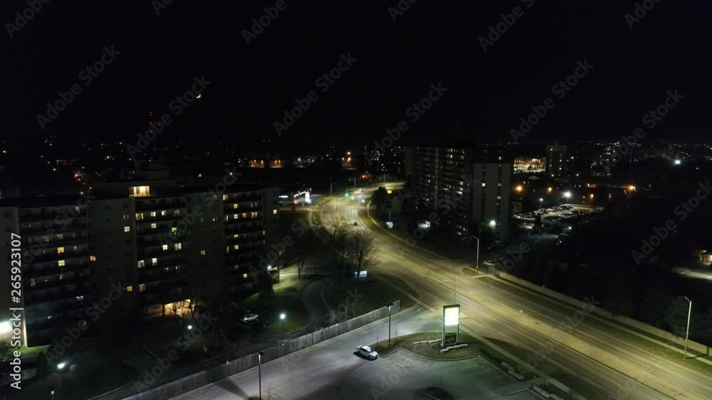 Red Car Driving Off Into Distance On Empty Road At Night In City Red Car Driving Off Into Distance On Empty Road At Night In City