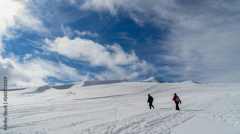 Image of a snow covered mountain plateau. Tourists walk and take pictures on a mountain plateau.