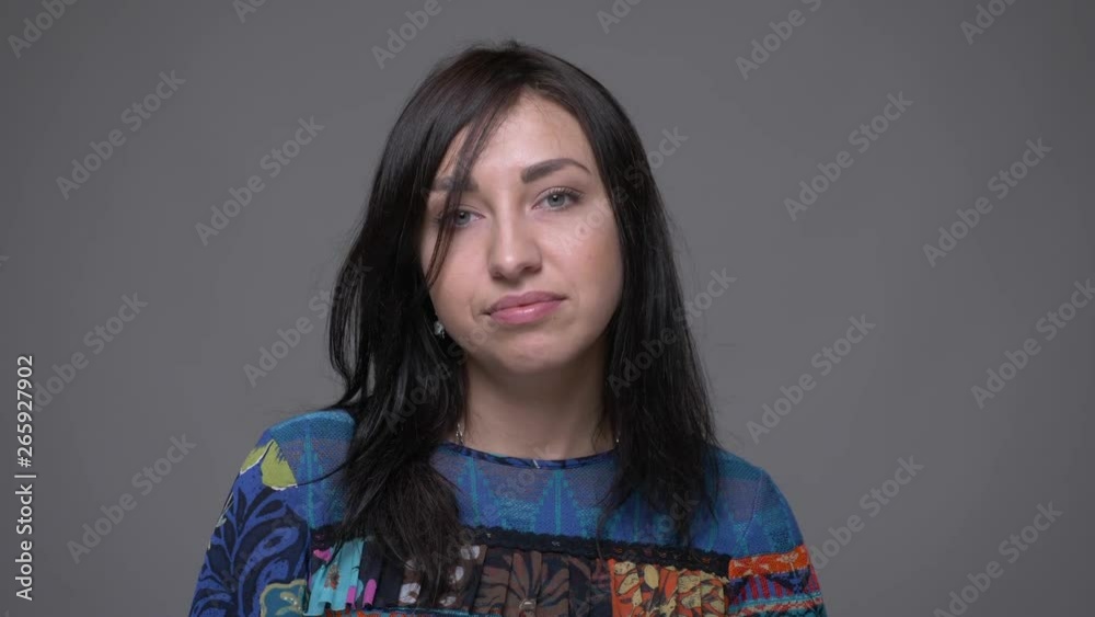 Closeup portrait of adult caucasian brunette female nodding saying yes looking at camera with background isolated on gray Closeup portrait of adult caucasian brunette female nodding saying yes looking at camera with background isolated on gray
