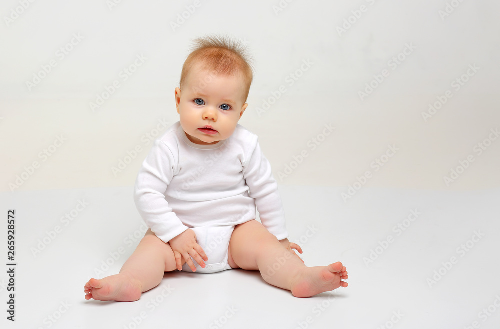 Charming blue-eyed baby 9 months old on white background in white clothes Charming blue-eyed baby 9 months old on white background in white clothes