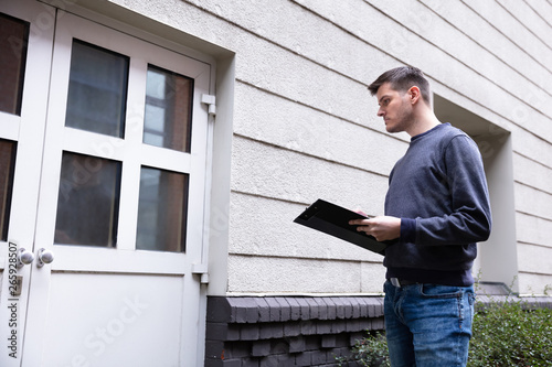 Service Man Standing In Front Of Closed Door