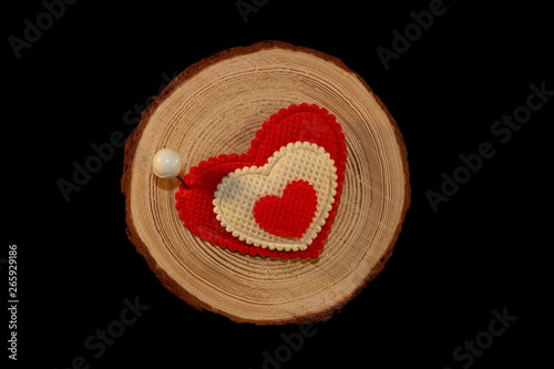 beautiful red heart is nailed to a wooden saw cut on a black background