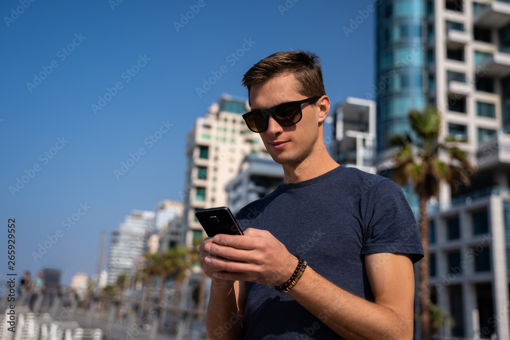 young man using the phone. City Skyline In Background young man using the phone. City Skyline In Background