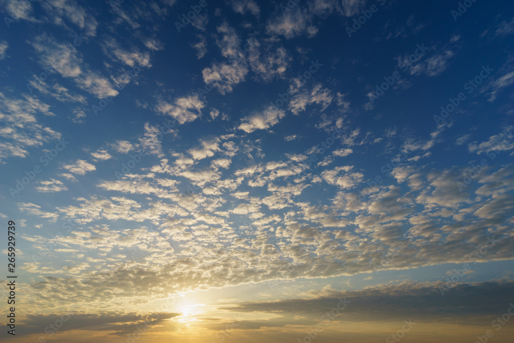 Rising sun over blue sky with cirrocumulus clouds Rising sun over blue sky with cirrocumulus clouds