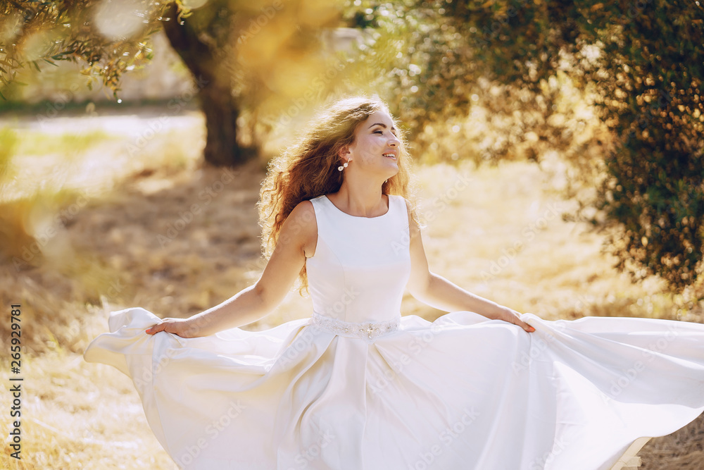 Beautiful long-haired bride in a magnificent white dress walking in nature Beautiful long-haired bride in a magnificent white dress walking in nature