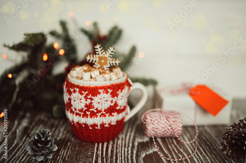 Warm cup of cacao or coffee with marshmallows and gingerbread in winter, holidays concept, Christmas mood. Mug and gift boxon the vintage wooden background. Concept of winter holidays and coziness. photo