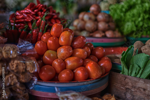 Asian food ingredients corner. Organic fresh agricultural product at farmer market. Fresh tomatoes  onions  eggplant  are packaged in simple containers and displayed for sale at an produce stand.