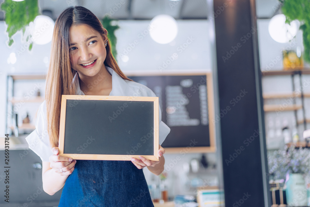 Pretty young asian waitress standing arms crossed in cafeteria.Coffee Business owner Concept. barista in apron smiling at camera in coffee shop counter Pretty young asian waitress standing arms crossed in cafeteria.Coffee Business owner Concept. barista in apron smiling at camera in coffee shop counter