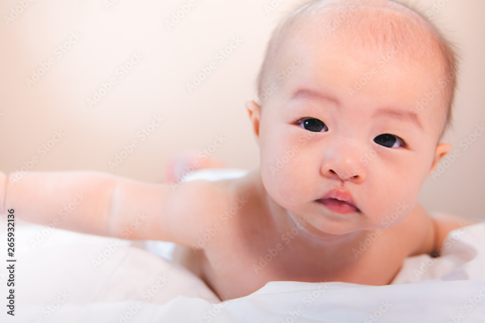 Asian baby happy in the room.Asian baby girl lying down on bed . Asian baby happy in the room.Asian baby girl lying down on bed .