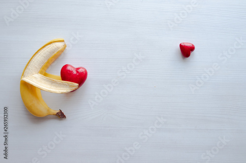 A banana holds a heart shape. Love concept