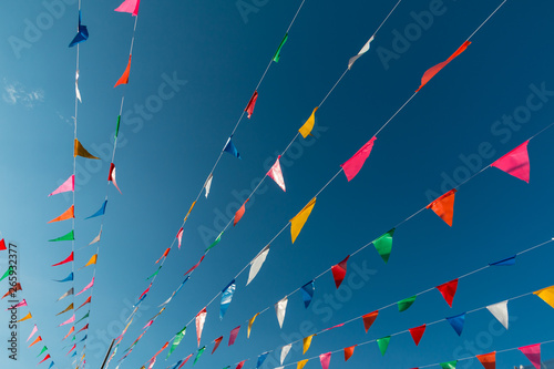 Colorful flags bunting against blue sky. Happy summer celebration concept.