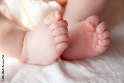 the legs of the baby with little pink fingers