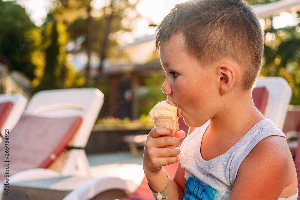 Cute baby eating ice cream in a waffle cone in the sunlight Cute baby eating ice cream in a waffle cone in the sunlight