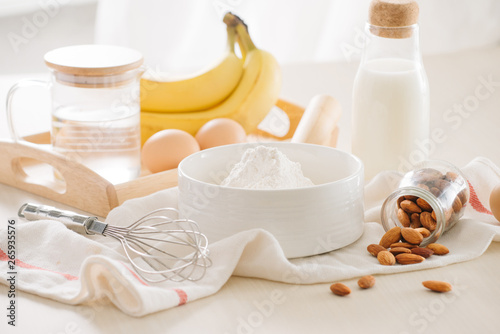 ingredients and tools to make banana cake on white background