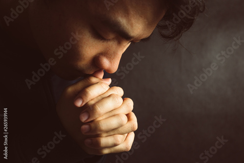 Praying Man Against Dark Background With Copy Space