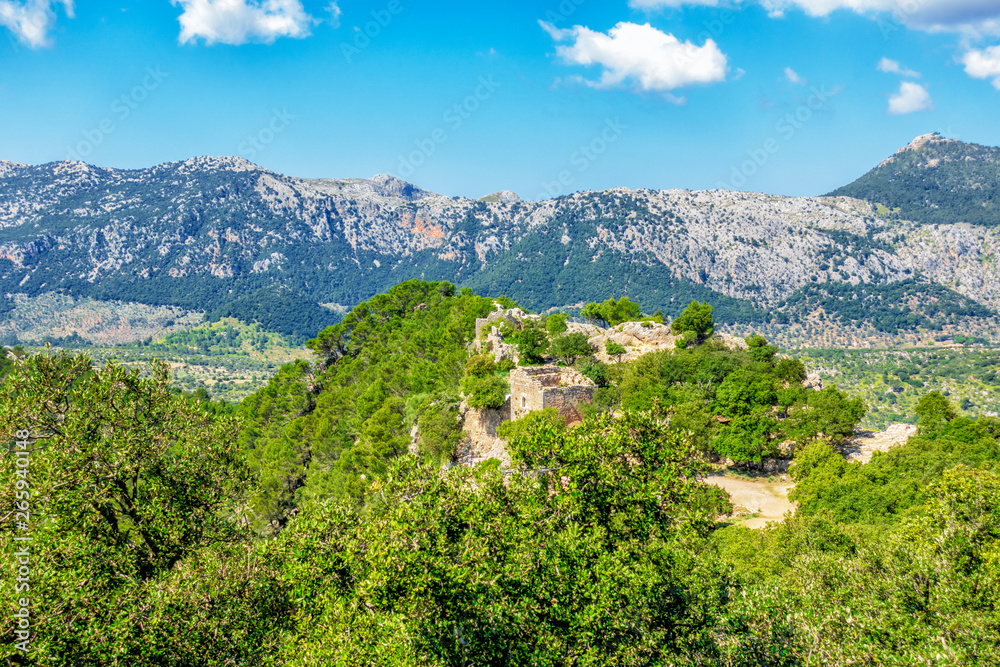 Blick auf die Ruinen der Felsenburg Castell d’Alaró vor dem Bergzug der Serra de Son Torella mit dem Puig de l`Offre im Tramuntana Gebirge auf Mallorca