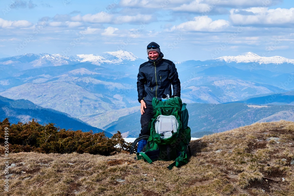Obraz premium tourist mountaineer on the top of a snow-covered mountain
