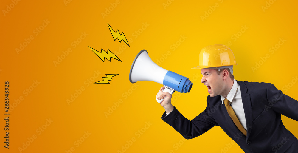 Fototapeta premium Young architect constructor yelling with megaphone and copyspace
