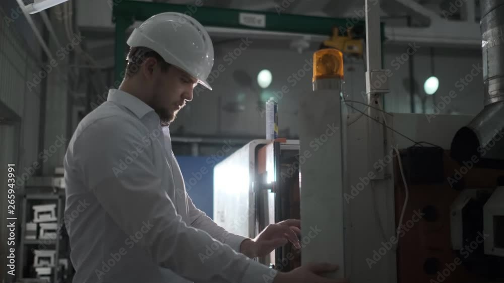 An engineer is managing plastic-making equipment through control board. 4k An engineer is managing plastic-making equipment through control board. 4k
