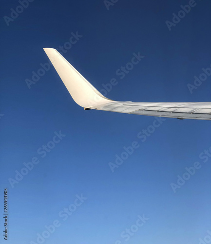 Airplane wing in flight - blue and clean sky