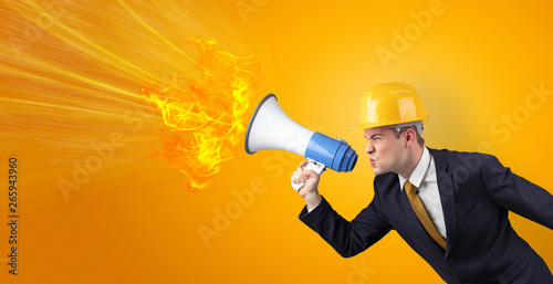 Young architect constructor yelling with megaphone with copyspace