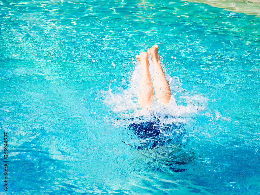 Mature woman playing swimming like a dauphin in a tropical water
