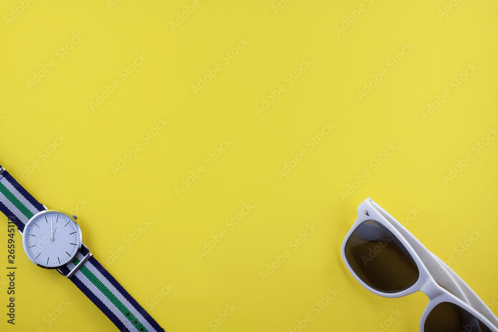 Modern watch and white sunglasses on yellow background. Copy space. Summer concept. Modern watch and white sunglasses on yellow background. Copy space. Summer concept.