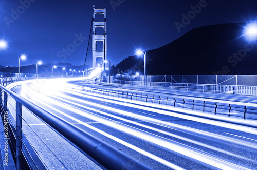 View of Golden Gate Bridge with lots of cars passing through in San Francisco at night.