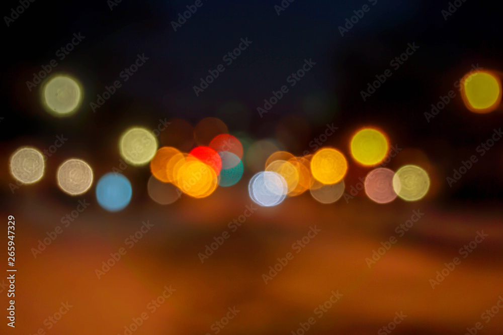 Closeup blurred and bokeh reflection lighting of cars head lights on the road with traffic on night time city.
