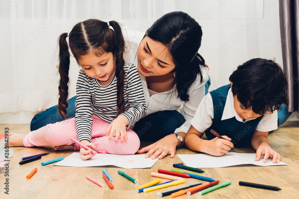 Happy child kid boy and girl son kindergarten drawing on peper teacher education with beautiful mother Happy child kid boy and girl son kindergarten drawing on peper teacher education with beautiful mother