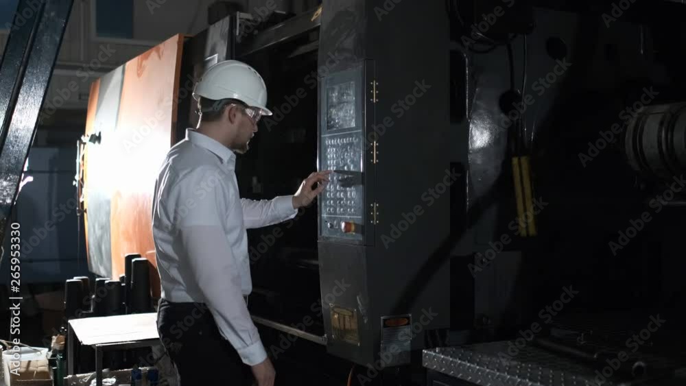 An engineer is managing plastic-making equipment through control board. 4k An engineer is managing plastic-making equipment through control board. 4k