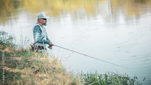Fisherman with spinning on the river bank.