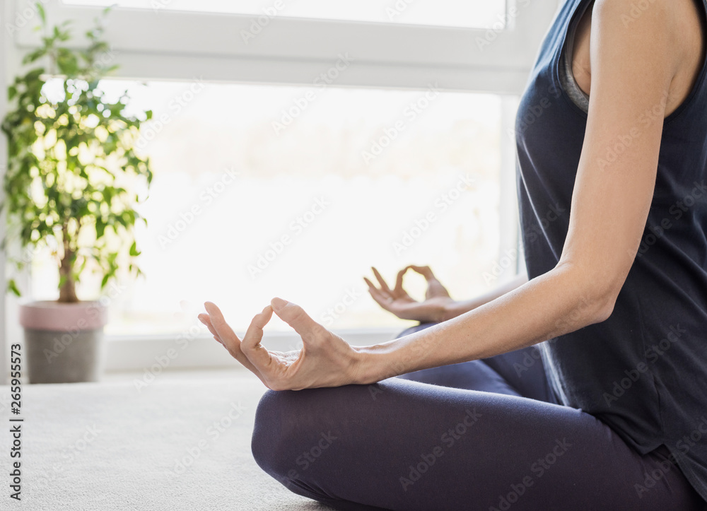 Young woman meditating at home. Girl practicing yoga. Harmony, balance, meditation, relaxation, healthy lifestyle concept