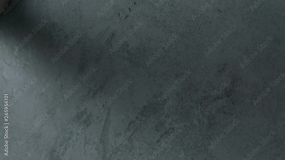Slow motion man hand touches decorative concrete finish