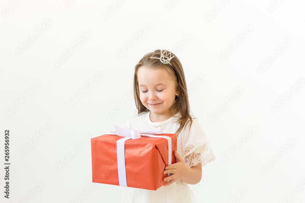 Childhood, children and holiday concept - little girl in white dress with gift box on white background Childhood, children and holiday concept - little girl in white dress with gift box on white background