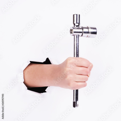 Stacked wrench in the hand of a girl. Symbol of hard work, feminism and labor day. Isolate on white background.