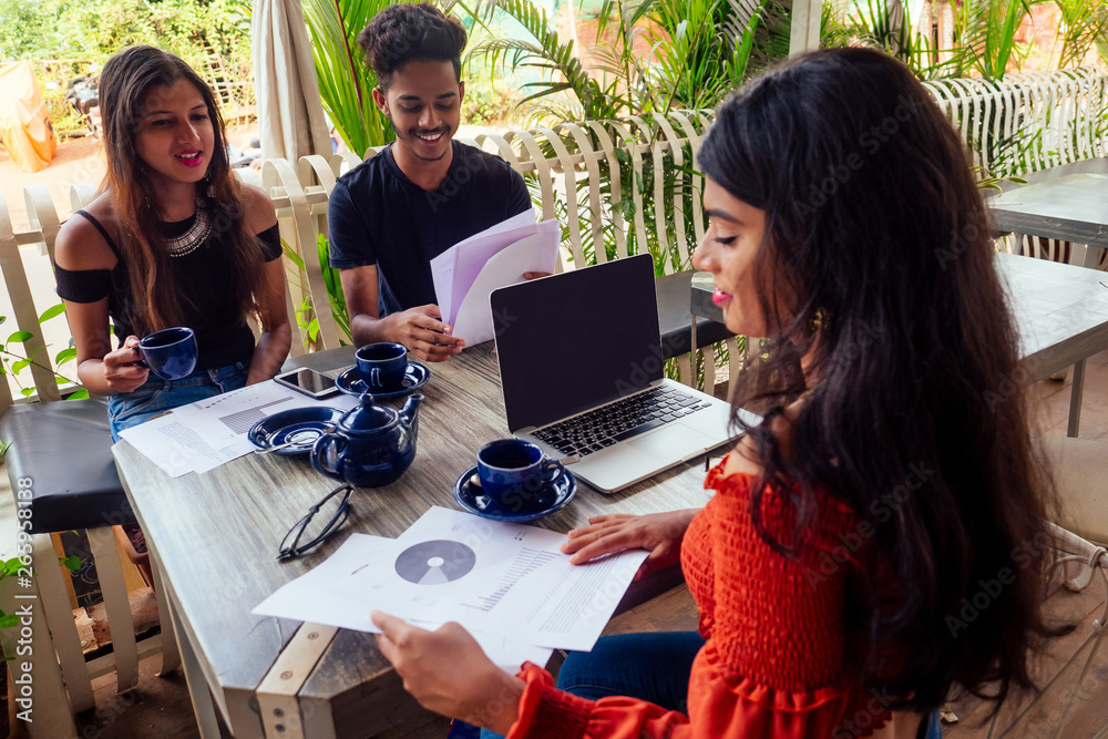 Multicultural group of people discussing by laptop in summer cafe surfing online freelancer freelance Multicultural group of people discussing by laptop in summer cafe surfing online freelancer freelance