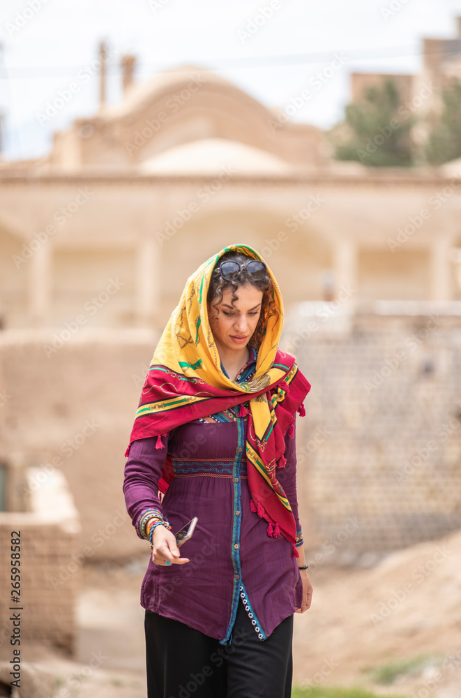 Fototapeta premium young beautiful iranian lady outside in an old village