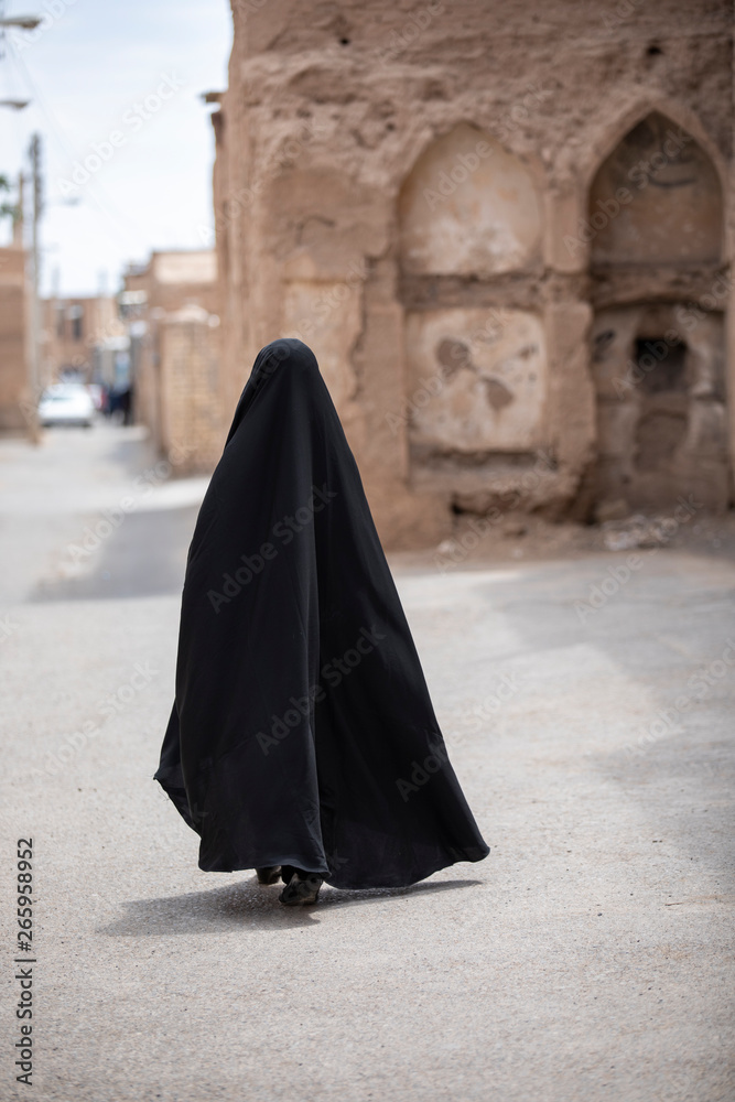 fully covered iranian lady walking in a n old viallage in Iran fully covered iranian lady walking in a n old viallage in Iran