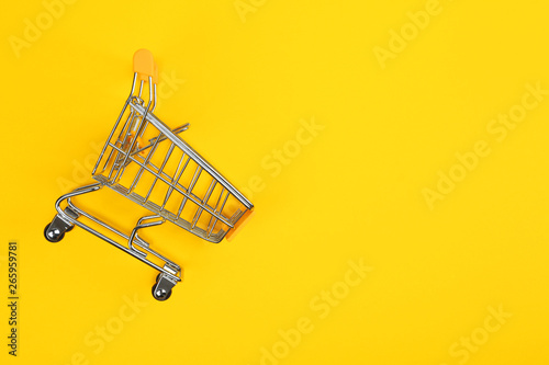 Empty shopping trolley on color background, top view. Space for text