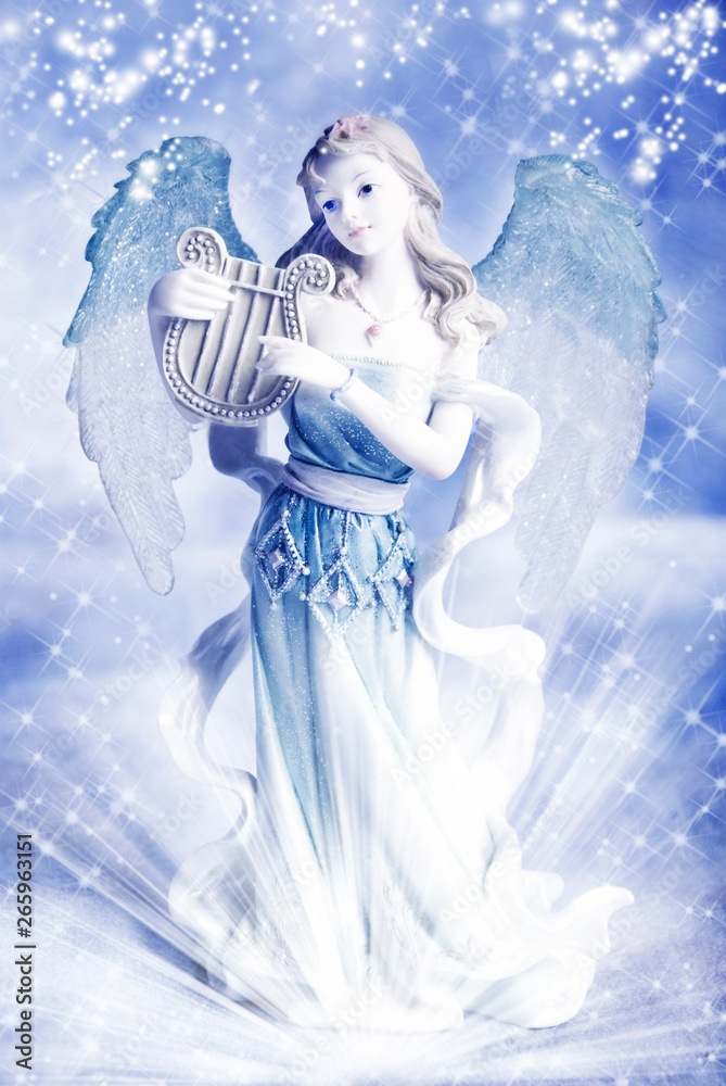 a beautiful angel archangel over blue winter backround with flakes of snow,  white stars and rays of light Stock Photo | Adobe Stock