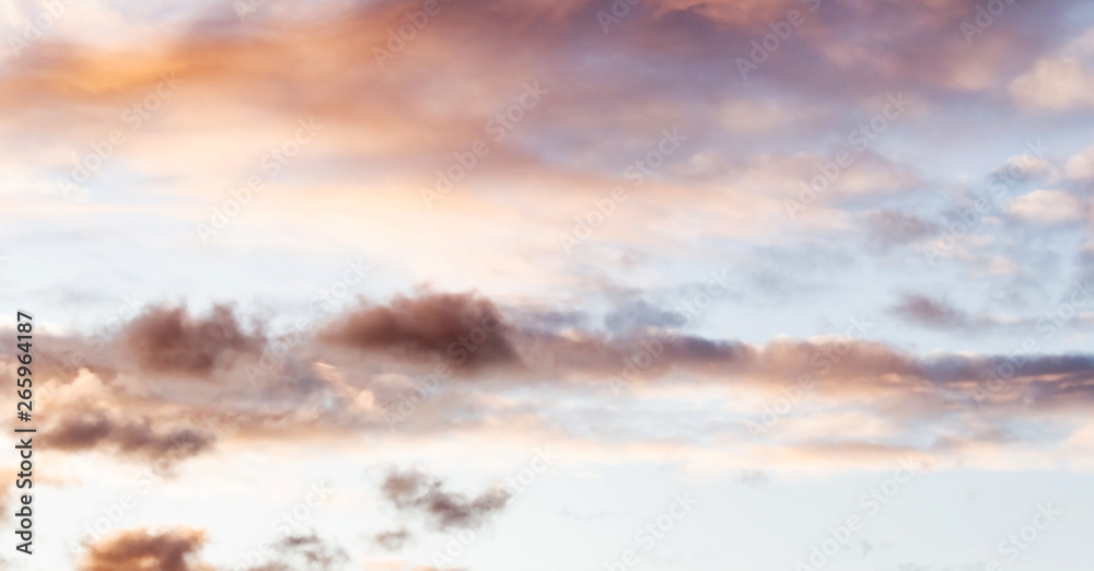 Fluffy pink clouds against a blue sky at sunset