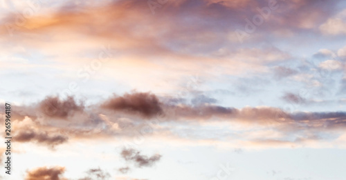 Fluffy pink clouds against a blue sky at sunset