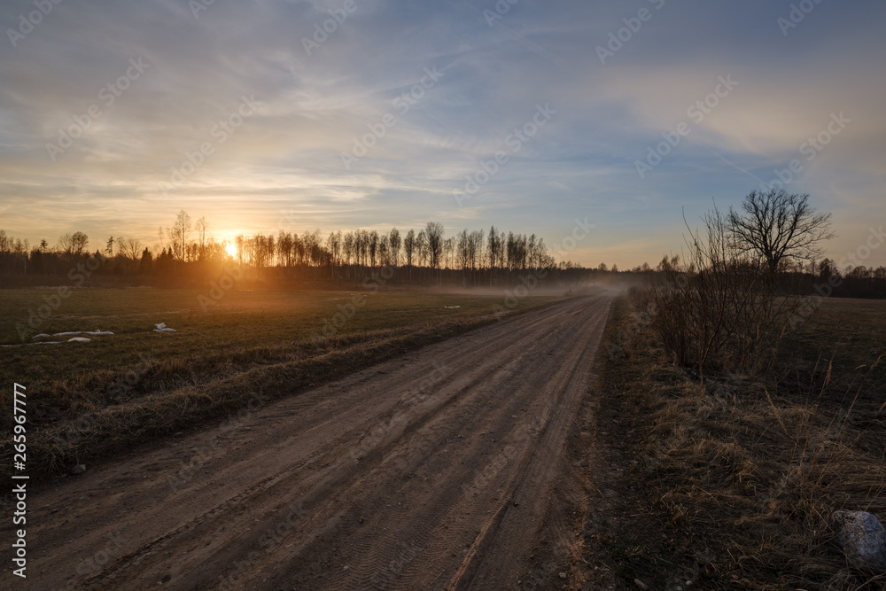 b eautiful countryside gravel road in sunset