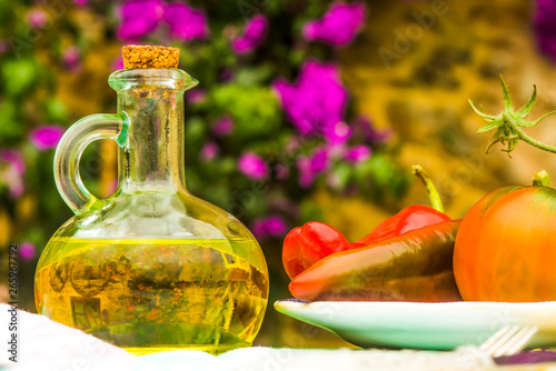 Virgin olive oil in a rustic bottle, outdoors.