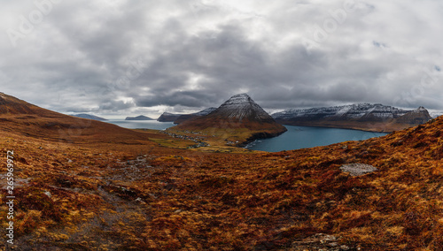 Panoramic view from Kap Enniberg to the small village Viðareiði, its fjords, Kunoy island and snow-covered mountains (Faroe Islands, Denmark, Europe) photo